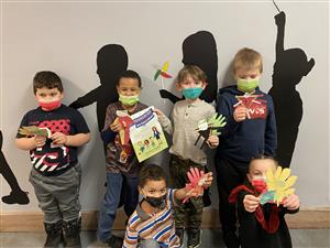 Photo shows six students holding a book about superheroes written by Kamala Harris